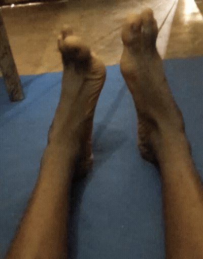 A Person 'S Feet Are Laying On A Blue Yoga Mat GIF