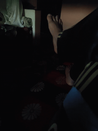 A Person 'S Feet Are Standing On A Red And Black Blanket With Flowers On It GIF