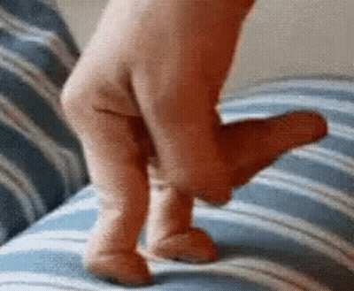 A Person 'S Foot Is Laying On A Blue And White Striped Couch . GIF