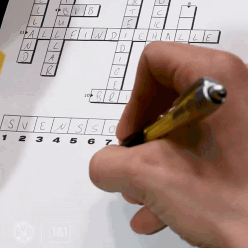 A Person 'S Hand Is Holding A Pen Over A Crossword Puzzle On A Piece Of Paper GIF