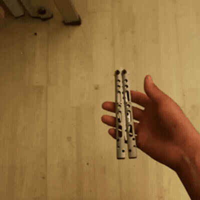 A Person 'S Hand Is Holding A Stapler On A Wooden Floor GIF