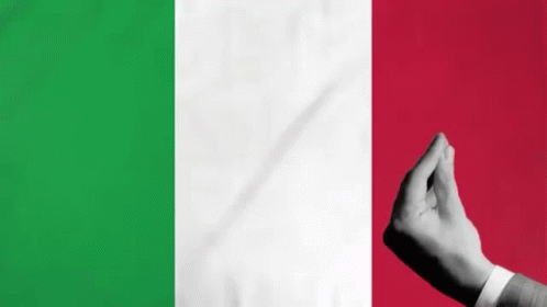 A Person 'S Hand Is Making A Heart Shape In Front Of A Flag Of Italy . GIF