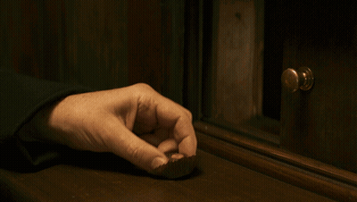 A Person 'S Hand Is Reaching For A Piece Of Chocolate On A Wooden Table GIF