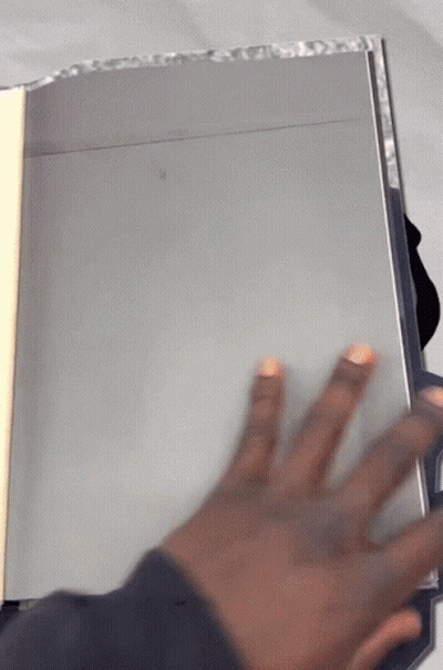 A Person 'S Hand Is Reaching Out Towards A Book GIF
