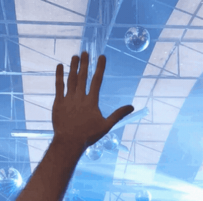 A Person 'S Hand Is Reaching Up Towards A Disco Ball GIF