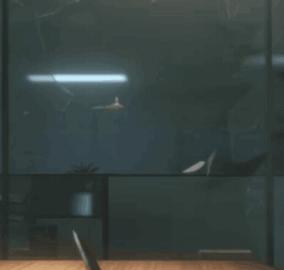 A Person Sitting At A Desk In A Dark Room GIF