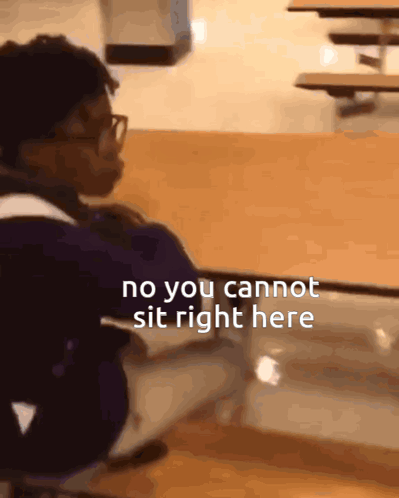 A Person Sitting At A Table With The Words No You Cannot Sit Right Here On The Bottom GIF
