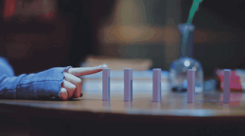 A Person Sitting At A Table With Their Finger Pointing GIF