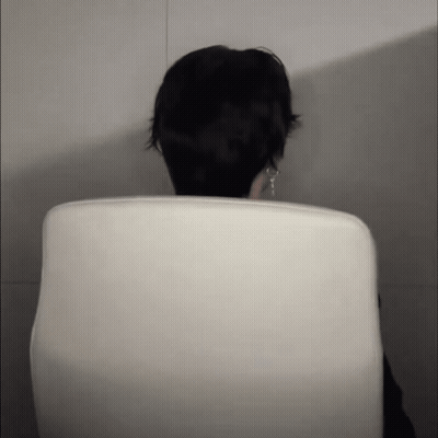 A Person Sitting In A White Chair With Their Head Visible GIF