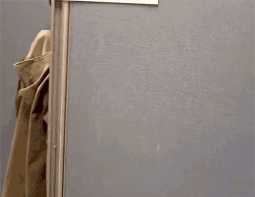 A Person Standing In A Cubicle With A Sign That Says ' News ' On It GIF