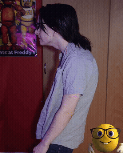 A Person Standing In Front Of A Poster That Says ' Nights At Freddy ' On It GIF