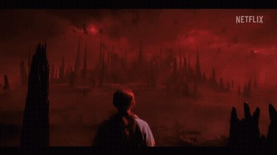 A Person Standing In Front Of A Red Background With Netflix Written On It GIF