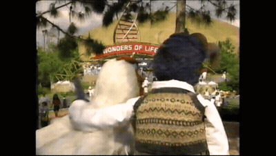 A Person Standing In Front Of A Sign That Says " Wonders Of Life " GIF