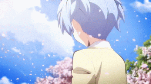 A Person Standing In Front Of A Tree With Cherry Blossoms GIF