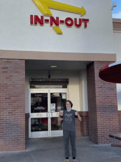 A Person Standing In Front Of An In N Out Restaurant GIF