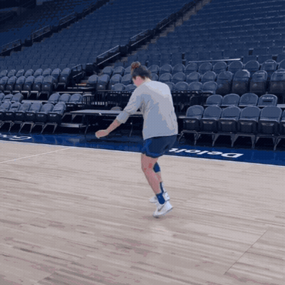 A Person Standing On A Basketball Court That Has The Word Delaware On The Floor GIF