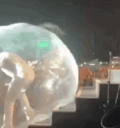 A Person Standing On A Stage With A Green Light Behind Them . GIF