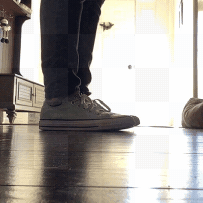 A Person Standing On A Wooden Floor Wearing White Converse Shoes GIF