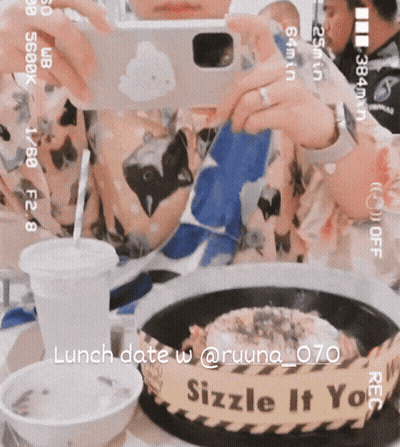 A Person Taking A Picture Of A Plate Of Food With A Sign That Says Sizzle It You On It GIF