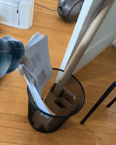 A Person Throws A Piece Of Paper Into A Trash Can That Says ' Papers ' On It GIF