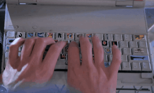A Person Typing On A Keyboard With Stickers On The Keys GIF