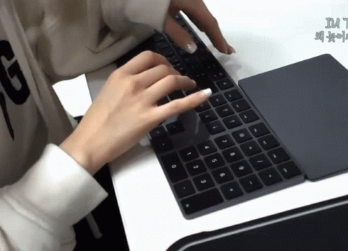 A Person Typing On A Keyboard With The Letter G On Their Sweater GIF