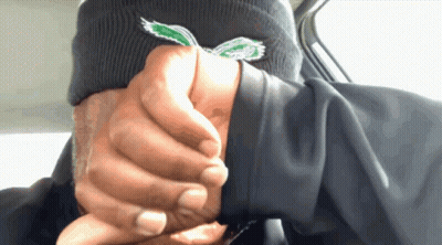 A Person Wearing A Black Beanie With A Green Eagle Embroidered On It GIF