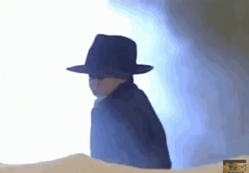 A Person Wearing A Black Hat And A Cape GIF