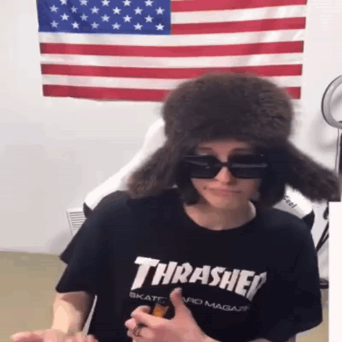A Person Wearing A Black Thrasher Shirt And A Fur Hat GIF