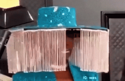 A Person Wearing A Blue Hat With A White Fringe On It . GIF