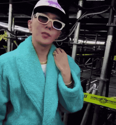 A Person Wearing A Blue Robe And Sunglasses Stands In Front Of A Yellow Tape That Says Gongjin Power GIF