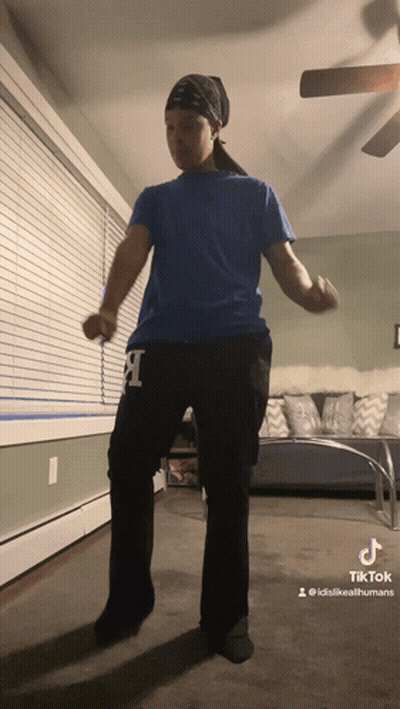 A Person Wearing A Blue Shirt And Black Pants With The Letter L On Them GIF