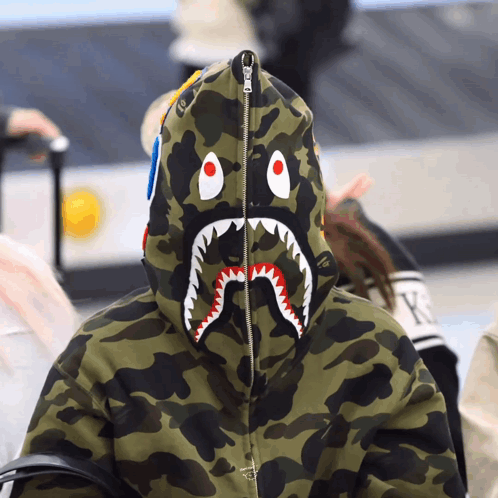 A Person Wearing A Camo Hoodie With A Shark Face On It GIF