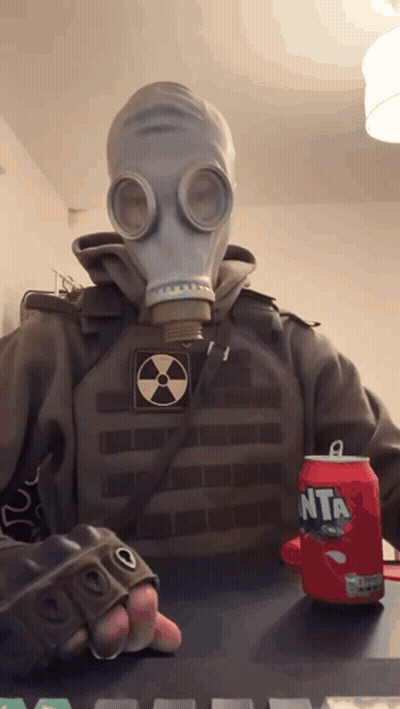 A Person Wearing A Gas Mask Holds A Can Of Fanta GIF