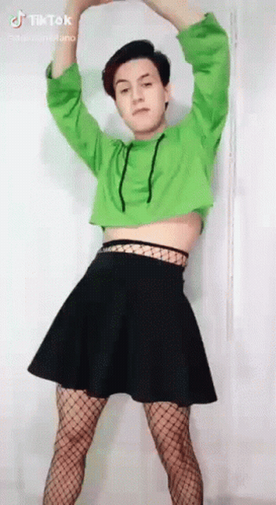 A Person Wearing A Green Crop Top And A Black Skirt Is Dancing . GIF
