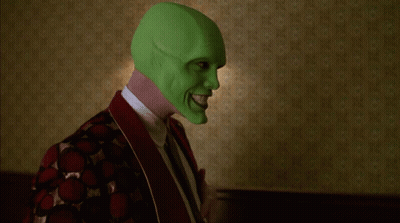 A Person Wearing A Green Mask Is Standing In Front Of Two Lamps GIF