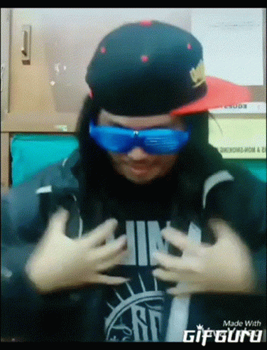 A Person Wearing A Hat And Sunglasses Is Made By Gifguru GIF