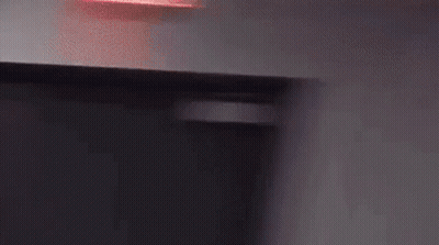 A Person Wearing A Hat Is Standing In Front Of A Wall . GIF