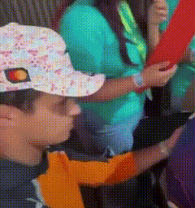 A Person Wearing A Hat With A Sun On It Is Holding A Red Object GIF