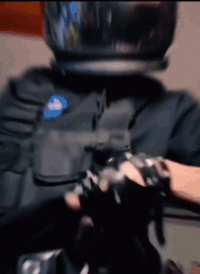 A Person Wearing A Helmet And Gloves Is Holding A Gun GIF