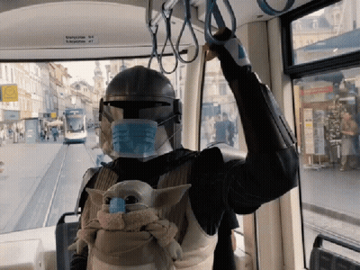 A Person Wearing A Mask And A Helmet Is Riding A Bus With A Sign That Says ' Bahnhof ' On It GIF