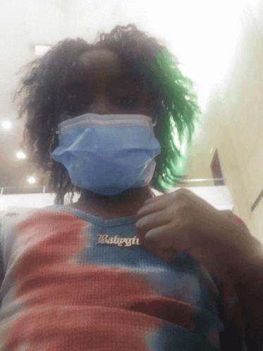 A Person Wearing A Mask And A Necklace With The Word Babygirl On It GIF
