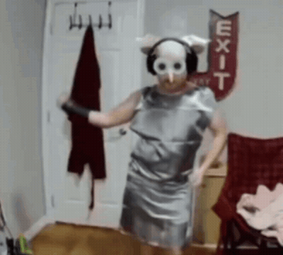 A Person Wearing A Mask And Headphones Is Dancing In Front Of An Exit Sign GIF