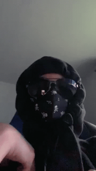 A Person Wearing A Mask And Sunglasses With Skulls On It GIF