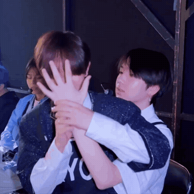 A Person Wearing A Nyc Shirt Covering Another Person 'S Face With Their Hands GIF