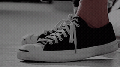 A Person Wearing A Pair Of Black And White Converse Sneakers GIF