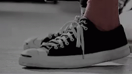 A Person Wearing A Pair Of Black And White Converse Sneakers GIF
