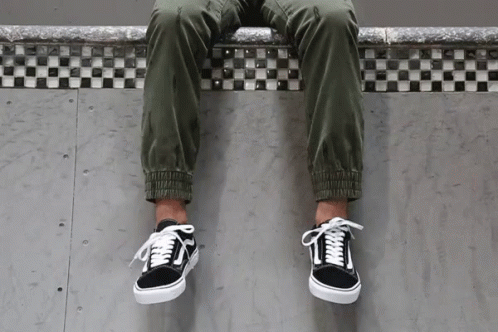 A Person Wearing A Pair Of Black And White Vans GIF