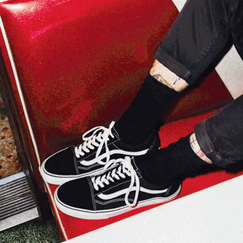 A Person Wearing A Pair Of Black And White Vans Sneakers GIF