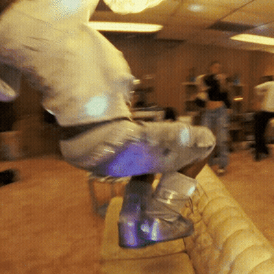 A Person Wearing A Pair Of Glow In The Dark Boots Is Jumping On A Couch GIF